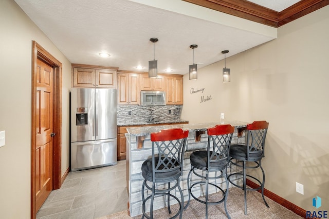 kitchen with sink, a breakfast bar, stainless steel appliances, tasteful backsplash, and decorative light fixtures