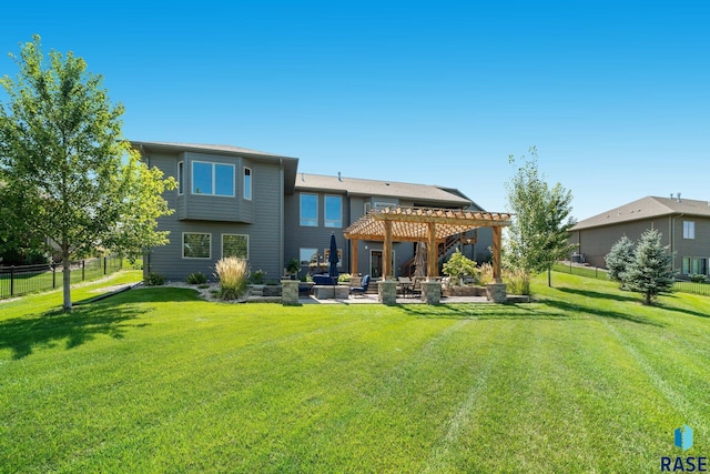 rear view of property with a yard, a pergola, and a patio area