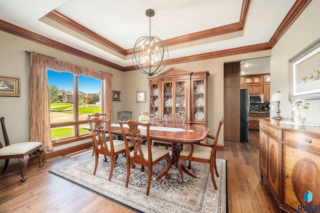 dining room featuring hardwood / wood-style flooring, crown molding, and a tray ceiling