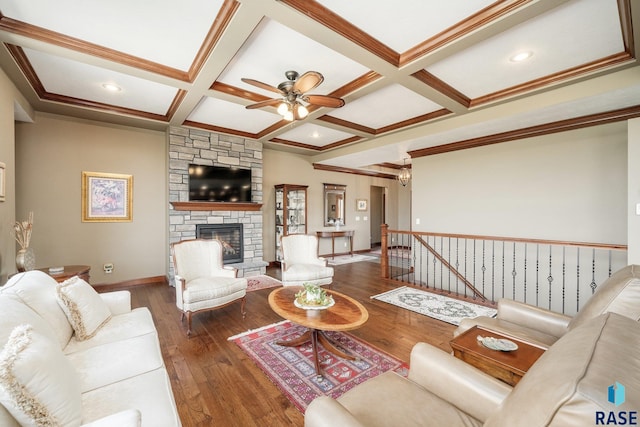 living room featuring a stone fireplace, dark hardwood / wood-style floors, beamed ceiling, coffered ceiling, and crown molding