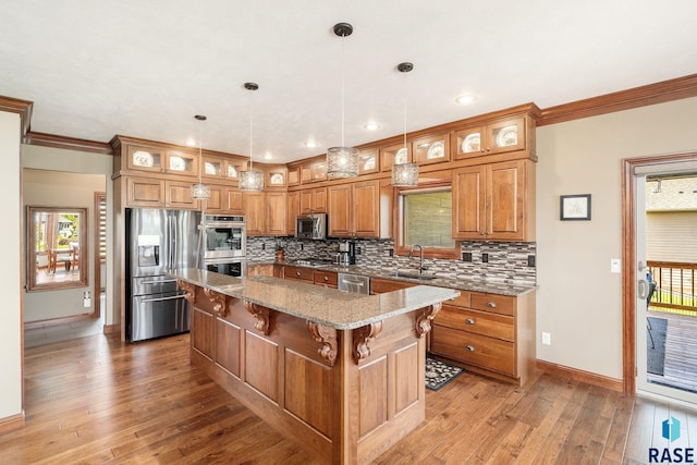 kitchen with sink, decorative light fixtures, a center island, and appliances with stainless steel finishes