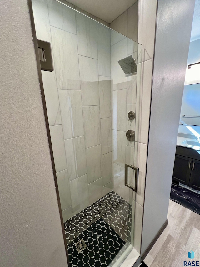 full bathroom featuring a shower stall and wood finished floors