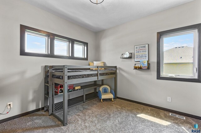 bedroom featuring baseboards, visible vents, and carpet