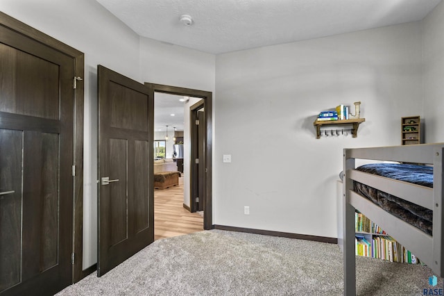bedroom featuring baseboards and light colored carpet