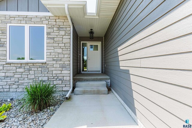 entrance to property with board and batten siding and stone siding