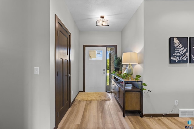 entryway featuring baseboards, light wood-style flooring, and visible vents