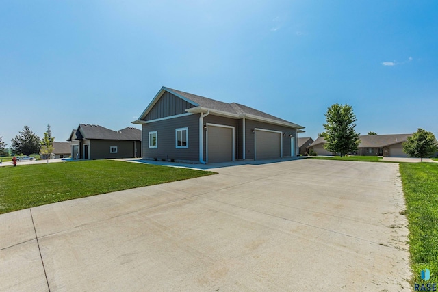 view of front facade featuring board and batten siding, an attached garage, a front lawn, and driveway