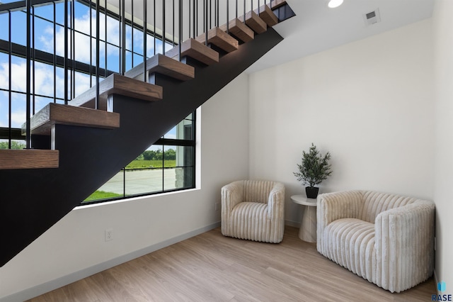 living area with recessed lighting, wood finished floors, visible vents, baseboards, and stairs