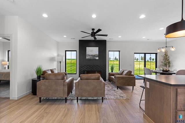 living area with a ceiling fan, recessed lighting, and light wood-style flooring