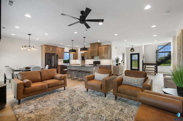 living area with light wood finished floors, visible vents, a wealth of natural light, and recessed lighting