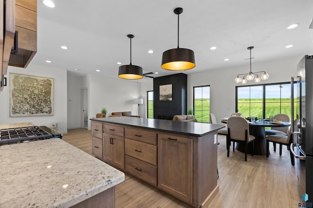 kitchen with a kitchen island, recessed lighting, light wood-type flooring, and freestanding refrigerator