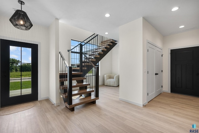 foyer entrance with stairway, baseboards, light wood-style floors, and recessed lighting