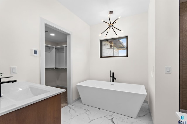 full bath with marble finish floor, a sink, a chandelier, and a freestanding bath