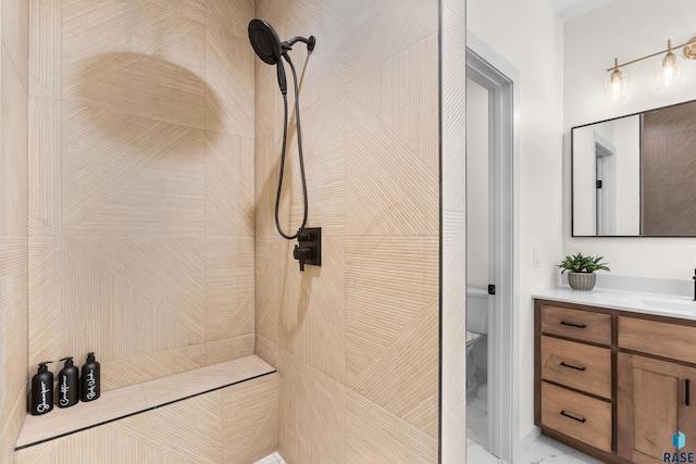 full bath featuring toilet, vanity, and tiled shower