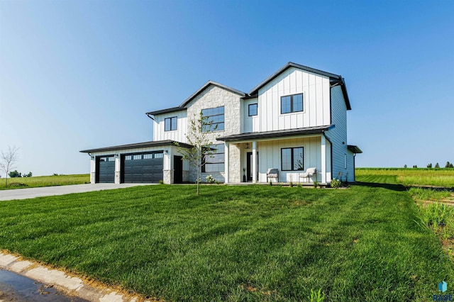 view of front of home with board and batten siding, driveway, a front lawn, and covered porch
