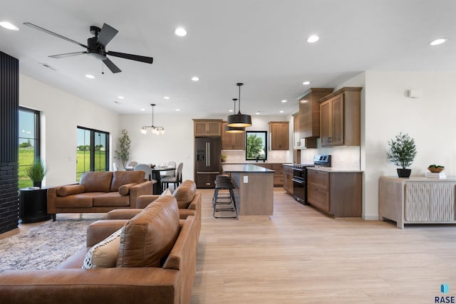 living room with light wood-style flooring, recessed lighting, ceiling fan, and a healthy amount of sunlight