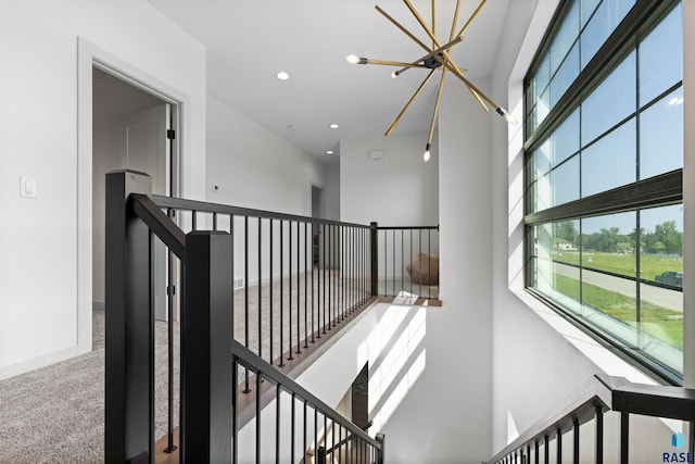 stairway featuring an inviting chandelier, carpet flooring, a towering ceiling, and recessed lighting
