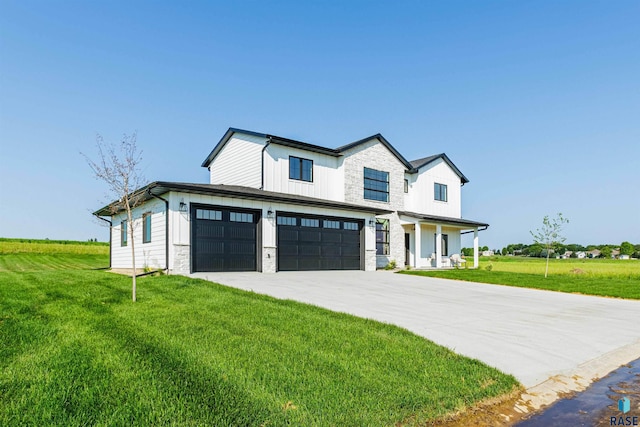 modern farmhouse style home featuring concrete driveway, a front lawn, stone siding, and a garage