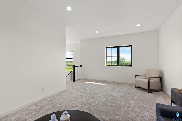 living area featuring recessed lighting, carpet, baseboards, and an upstairs landing