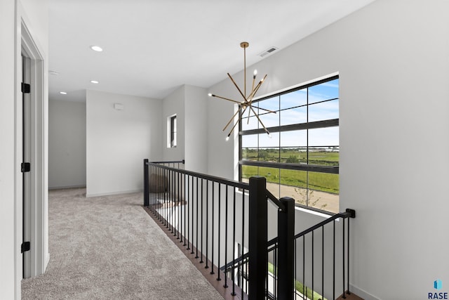 hallway with recessed lighting, an inviting chandelier, visible vents, an upstairs landing, and carpet floors