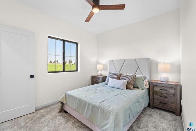 carpeted bedroom featuring baseboards and a ceiling fan