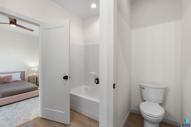 full bath with toilet, a ceiling fan, a tub to relax in, and wood finished floors