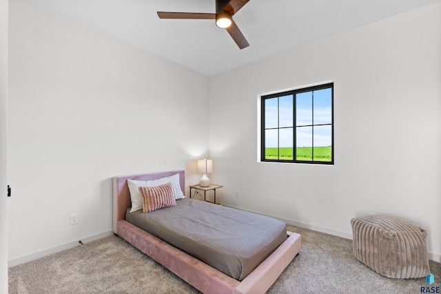carpeted bedroom featuring baseboards and a ceiling fan
