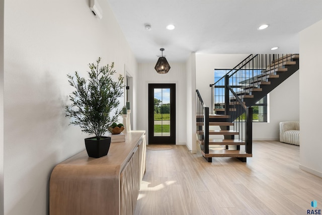 foyer with recessed lighting, baseboards, light wood finished floors, and stairs