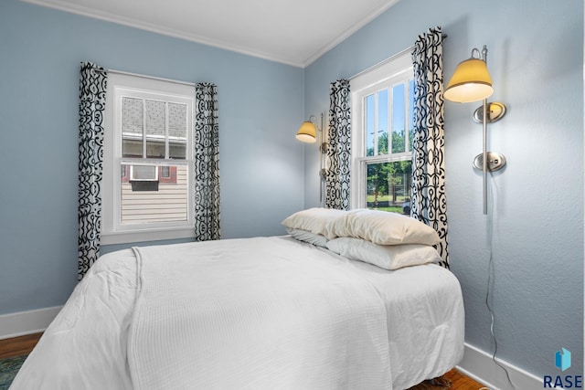 bedroom with dark hardwood / wood-style floors and ornamental molding