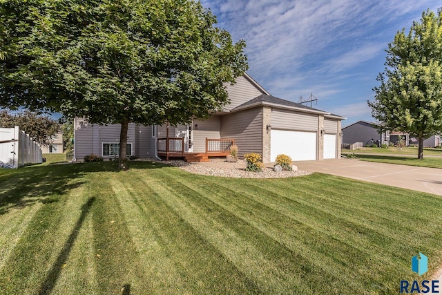 view of front of home featuring a front yard, a garage, and a wooden deck