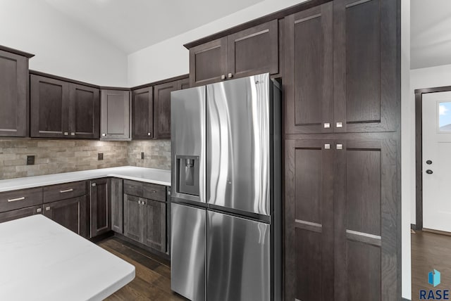 kitchen with decorative backsplash, dark hardwood / wood-style flooring, lofted ceiling, dark brown cabinets, and stainless steel refrigerator with ice dispenser