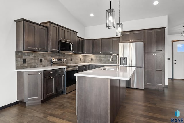 kitchen with dark brown cabinetry, pendant lighting, sink, appliances with stainless steel finishes, and dark hardwood / wood-style floors