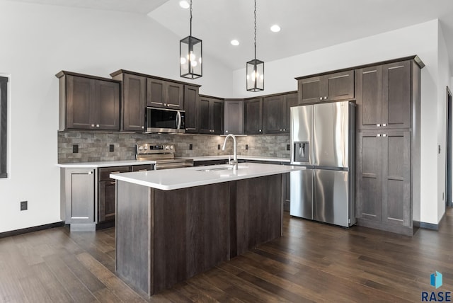 kitchen with appliances with stainless steel finishes, dark hardwood / wood-style floors, decorative light fixtures, and sink