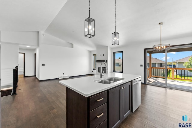 kitchen featuring lofted ceiling, a kitchen island with sink, sink, and pendant lighting