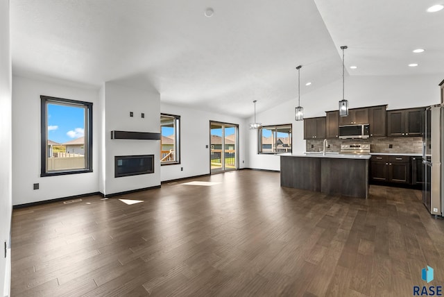 kitchen with pendant lighting, a center island with sink, stainless steel appliances, and plenty of natural light