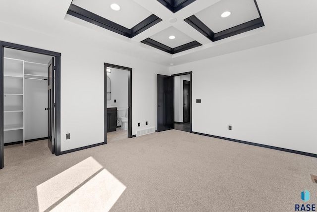 unfurnished bedroom featuring coffered ceiling, connected bathroom, beamed ceiling, a closet, and light colored carpet