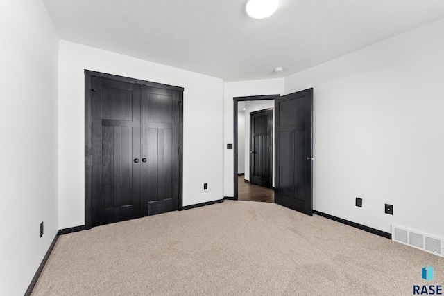 unfurnished bedroom with carpet flooring and a closet