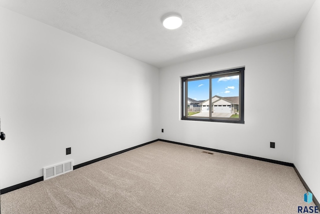 spare room with a textured ceiling and carpet flooring