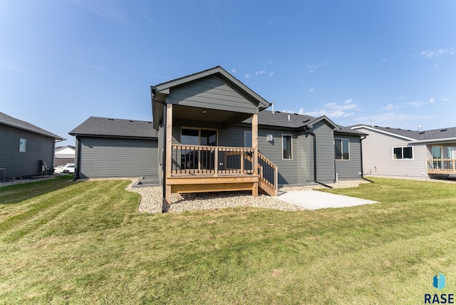 rear view of house featuring a lawn and a patio