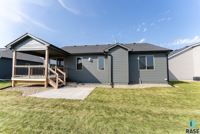 back of house with a lawn, a patio, and a wooden deck