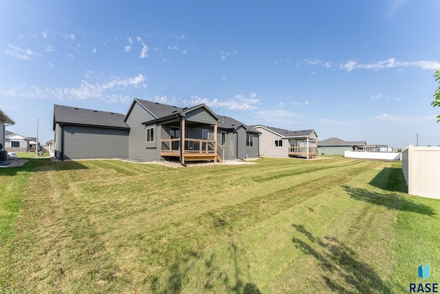 back of property featuring a wooden deck and a yard