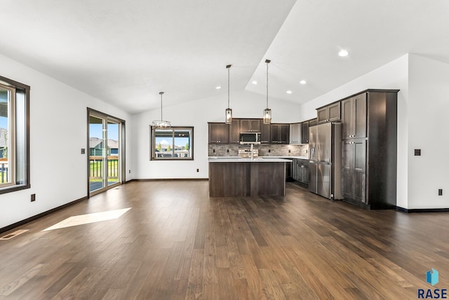 kitchen with dark hardwood / wood-style flooring, pendant lighting, stainless steel appliances, lofted ceiling, and dark brown cabinets