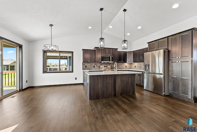 kitchen with vaulted ceiling, pendant lighting, stainless steel appliances, and plenty of natural light