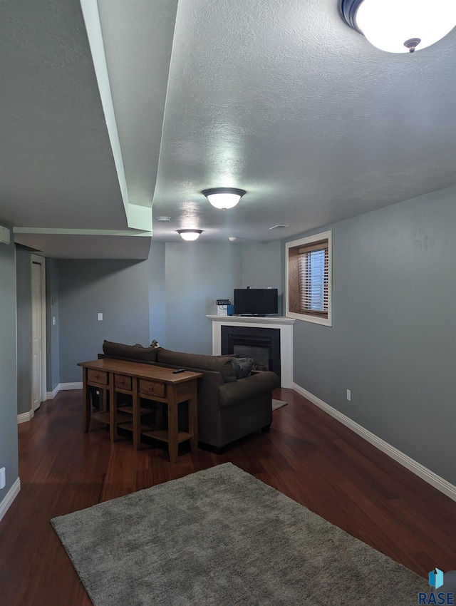 living room featuring dark hardwood / wood-style flooring and a textured ceiling