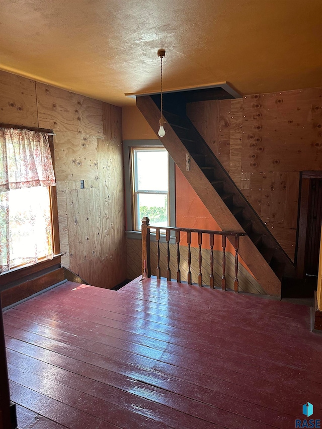 101 N Seaman St, Delmont, SD 57330 - interior space featuring stairs, a textured ceiling, wood walls, and hardwood / wood-style flooring