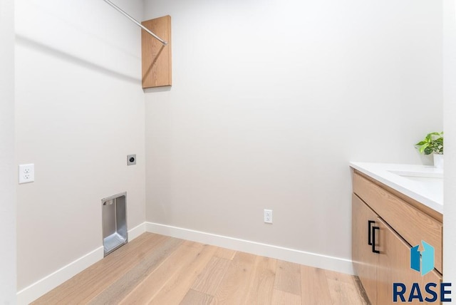 washroom with cabinets, sink, light hardwood / wood-style floors, and electric dryer hookup