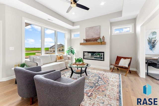 living room featuring light wood-type flooring and ceiling fan