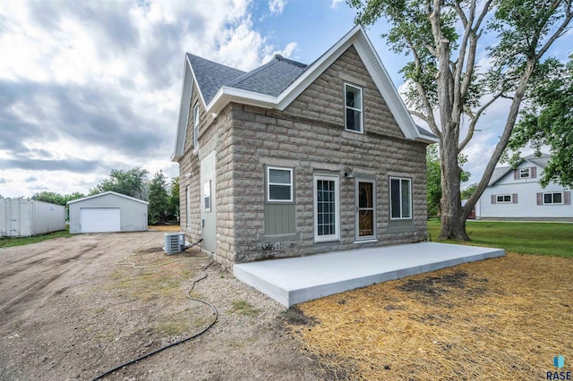 view of front of home featuring cooling unit, a front yard, an outdoor structure, and a garage