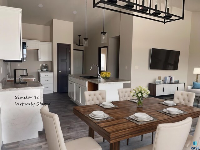 dining area featuring sink, a towering ceiling, and dark hardwood / wood-style flooring