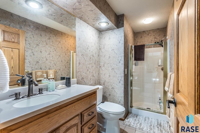 bathroom featuring vanity, tile patterned flooring, a textured ceiling, a shower with shower door, and toilet